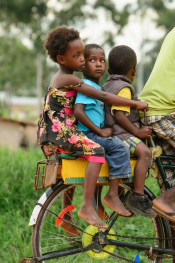African kids sit on the back of a bicycle
