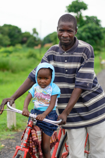 Father and daughter on a bike in Africa