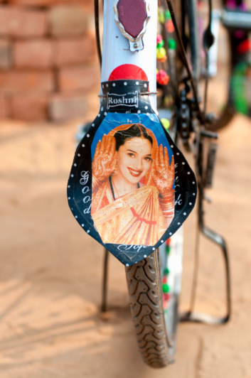 A Bollywood film star picture appears on a bike fender.