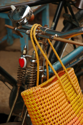 A handbag is slung over bicycle handlebars in India.
