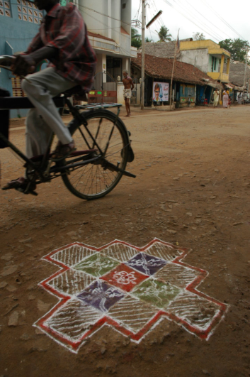 A cyclist pedals down a street in India.