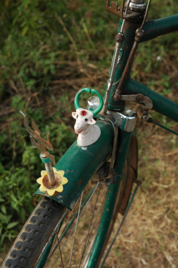 A hindu god sits on top of a bicycle fender in India.