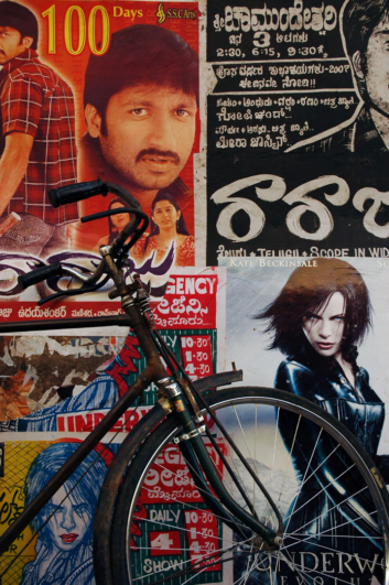 bicycle leaned against Indian movie posters