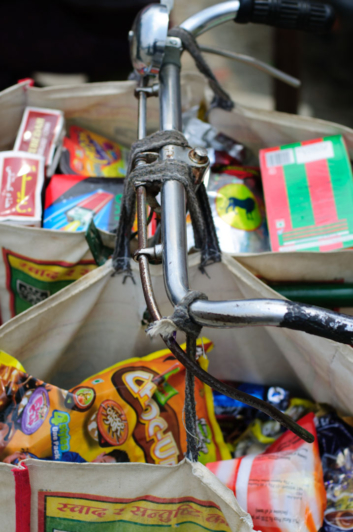 Shopping bags are hung on the handlebars of a bike in Nepal.