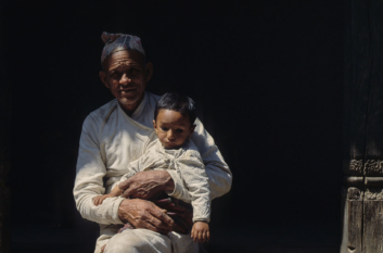 A grandfather holds his grandchild in the Kathmandu valley.