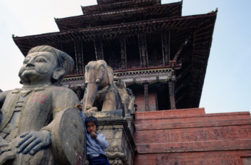 Nepalese boy leans against a temple in Bhaktapur.
