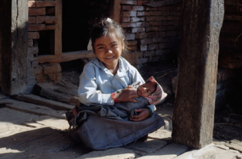 A young girl holds a baby in Nepal.