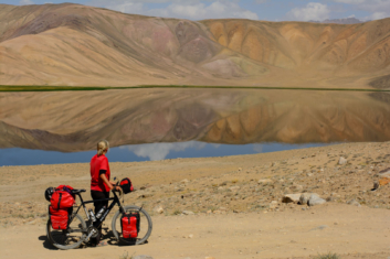 Cyclist looks out over Bulun Kul lake near the Pamir highway.