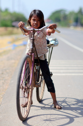A Cambodian girl with her bicycle.