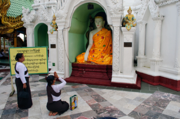 Prostrating before a Buddha statue in the Shwedagon pagoda.