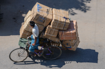 A rickshaw is overloaded with boxes in Myanmar.