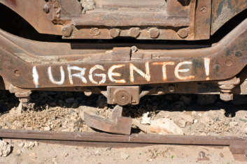Urgente is painted on train wheels in Bolivia.