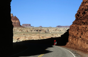 A cyclist rides through the American Southwest.
