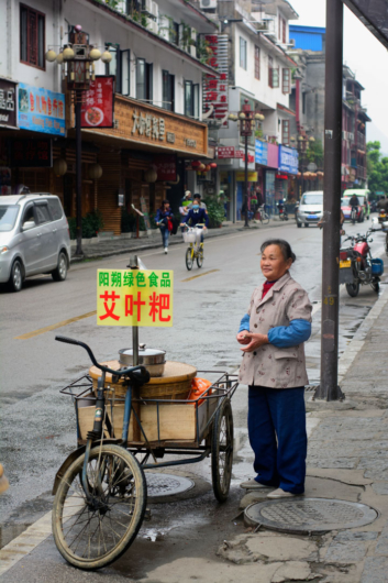 A Chinese lady sells food from her cargo bike.