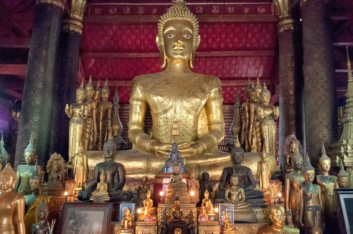 Buddha statues stand in a wat in Luang Prabang.