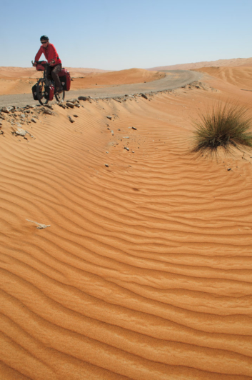 Cycling past sand dunes in Oman.