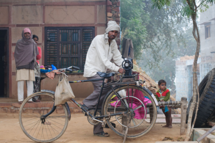 A bicycle powers a sewing machine in Fatehpur Sikri, India.