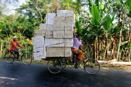A rickshaw carrying boxes cycles past in Bangladesh.