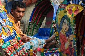 A chauffeur sits in his rickshaw in Dhaka.