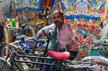 A man sits in a rickshaw in Dhaka.