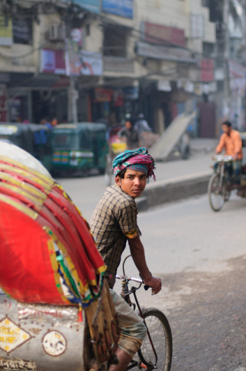 A rickshaw chauffer glances back in Dhaka, Bangladesh.