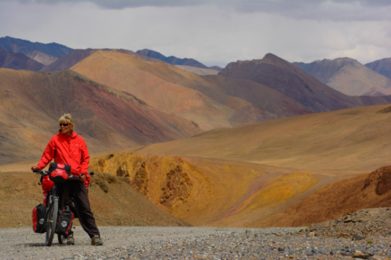 A touring cyclist stands near the top of the Ak Baital Pass in Tajikistan.