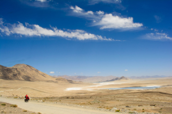 cycling through the vast desert of the pamir highway in tajikistan
